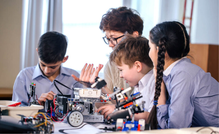 Teacher building robot with three children
