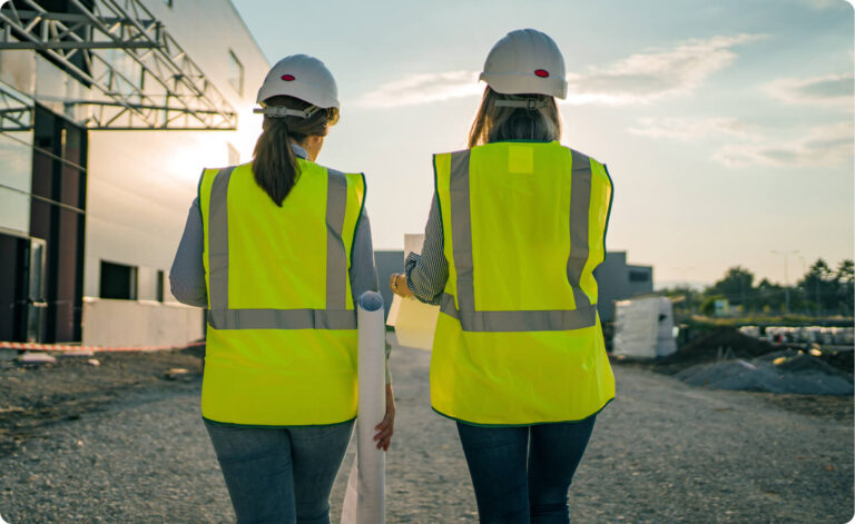 Two women civil engineers in hi-vis vest and hard hats
